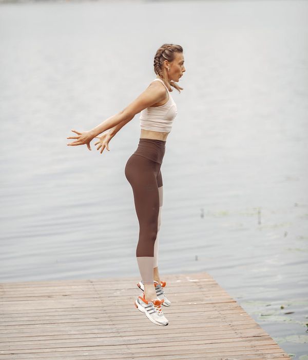 Woman in a dynamic cardio pose, feeling energized and focused.